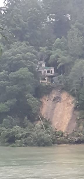 The slip at Paturoa Road in Titirangi as seen from across the bay.