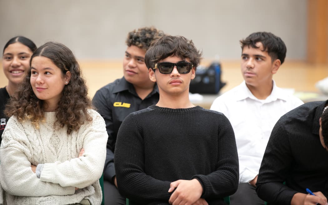 One student on the Opposition side of the mock debate sits with sunglasses on to support the argument against uniforms.
