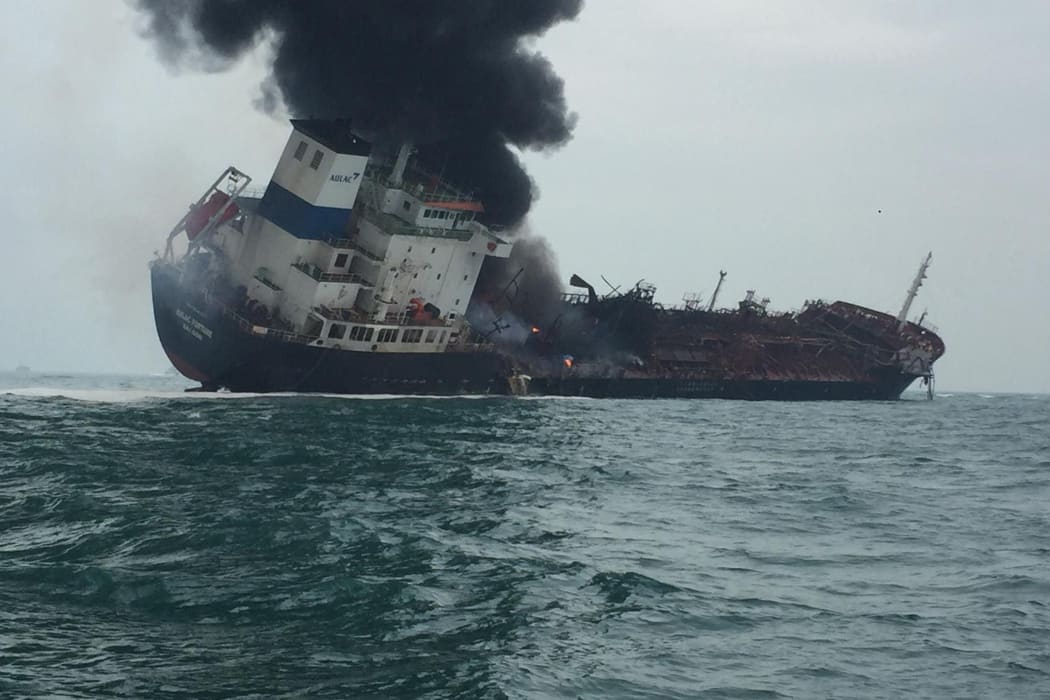 Smoke rises from an oil tanker believed to be the Aulac Fortune as it tilts to one side after it exploded in the waters near Hong Kong.