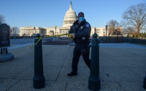 A member of the Capitol police tapes off access to the US Capitol in Washington, DC after the riot by Trump supporters.