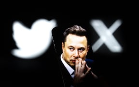 An effigy of Elon Musk is seen on a mobile device with the X and Twitter lgoso in the background in this photo illustration on 23 July, 2023 in Warsaw, Poland. (Photo by Jaap Arriens/NurPhoto) (Photo by Jaap Arriens / NurPhoto / NurPhoto via AFP)