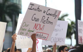 Protesters hold signs during a rally for gun control at the Broward County Federal Courthouse in Fort Lauderdale, Florida on February 17, 2018.