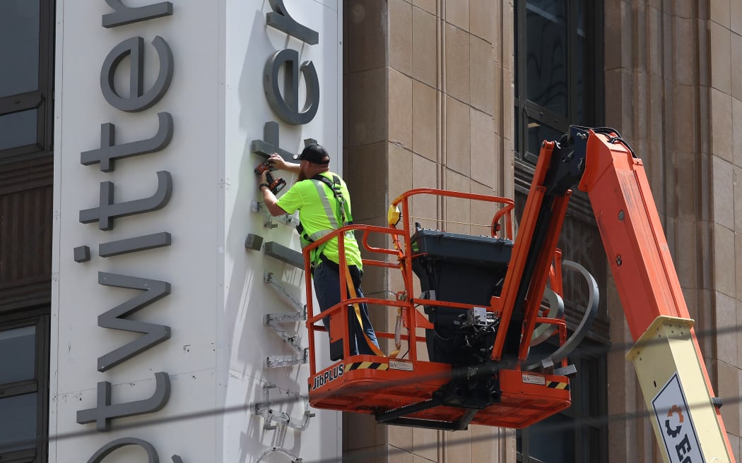 A worker removes letters from the Twitter sign that is posted on the exterior of Twitter headquarters on July 24, 2023 in San Francisco, California. Workers began removing the letters from the sign outside Twitter headquarters less than 24 hours after CEO Elon Musk officially rebranded Twitter as "X" and has changed its iconic bird logo, the biggest change he has made since taking over the social media platform. San Francisco police halted the sign removal shortly after it began.