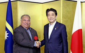 Nauru's President Baron Divavesi Waqa (L) shakes hands with Japan's Prime Minister Shinzo Abe.