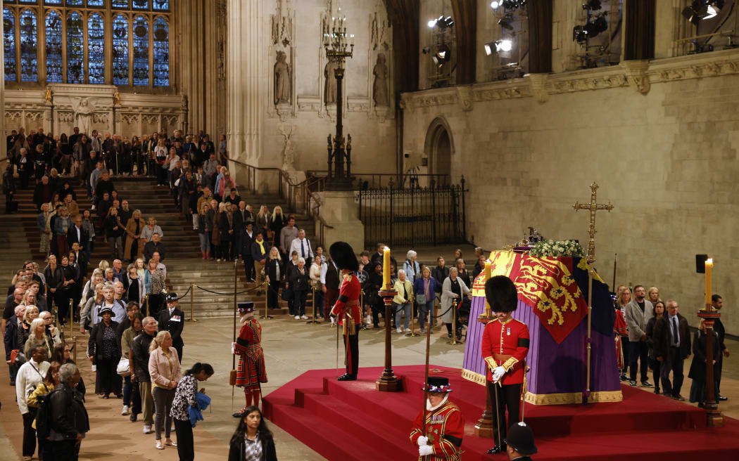 Members of the public pay their respects as they pass the coffin of Queen Elizabeth II as it Lies in State inside Westminster Hall, at the Palace of Westminster in London on September 15, 2022. - Queen Elizabeth II will lie in state in Westminster Hall inside the Palace of Westminster, until 0530 GMT on September 19, a few hours before her funeral, with huge queues expected to file past her coffin to pay their respects. (Photo by Odd ANDERSEN / POOL / AFP)