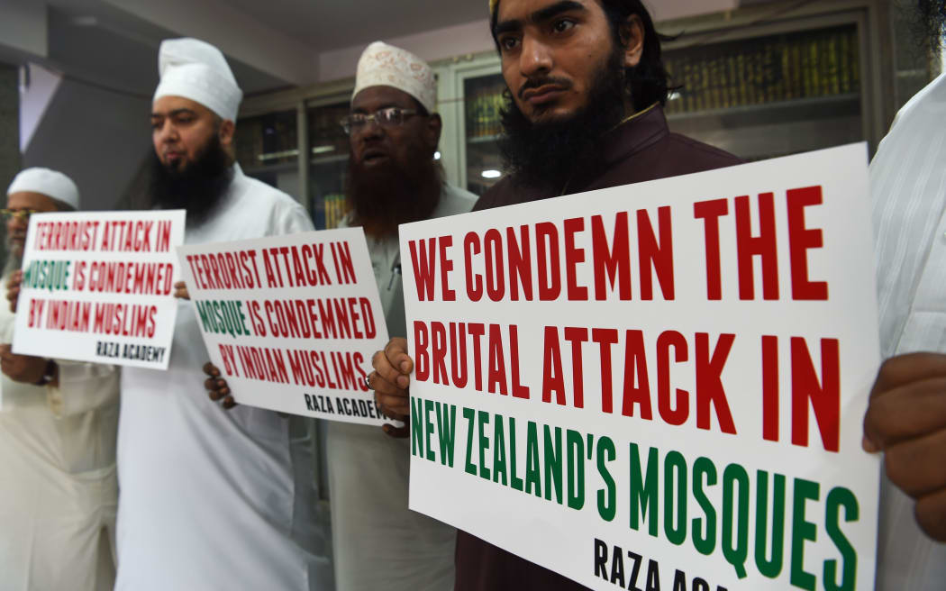 Indian Muslims and clerics in Mumbai hold posters to condemn the shooting.