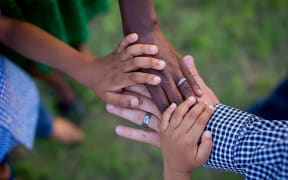 The way we see the world is informed by values inherent in our culture and environment. Different race kids holding hands.