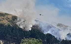A helicopter fighting a fire in the Port Hills on 20 November 2023.