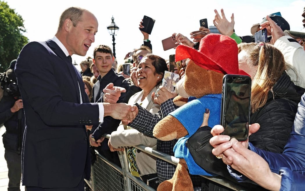 Prince William talks with members of the public waiting in the queue to pay their respects to Queen Elizabeth II.