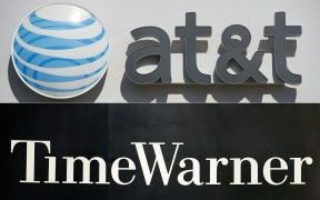 An AT&T cellphone store (TOP) in Springfield, Virginia, on October 23, 2014, and the Time Warner company logo on the front of the headquarters building, 24 November, 2003 in New York. 
A US judge cleared the AT&T merger with Time Warner with no conditions on June 12, 2018.