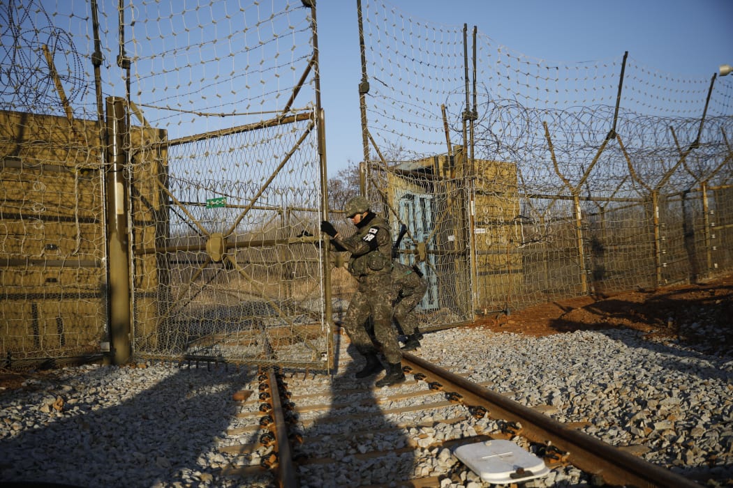 South Korean soldiers open the gate as the rails which leads to North Korea is seen, inside the demilitarized zone separating the two Koreas in Paju.