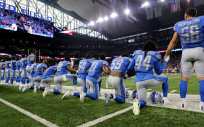 Members of the Detroit Lions take a knee during the playing of the national anthem before the start of a game at Ford Field in Detroit.