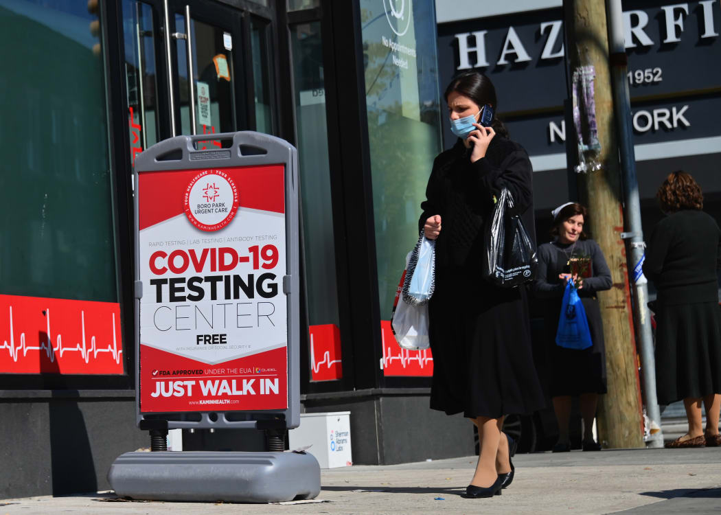 A person walks past a Covid-19 Testing Center in the Borough Park section of Brooklyn, one of the five boroughs of New York City on 9 October 2020.