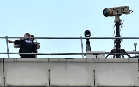Police officers stand near equipment on the rooftop of a building at London Gatwick Airport, south of London.