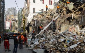 Rescue workers dig through the rubble of a building in Lebanon's capital Beirut in search of possible survivors from a blast at the adjacent port one month ago, after scanners detected a pulse, on September 3, 2020.