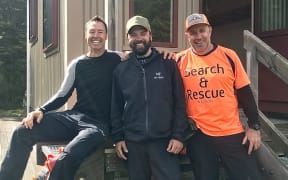 US hiker Chris Muse, centre, with LandSAR volunteers Dwayne Lohmann, left, and Kris Monopoli, right, who rescued him after he was swept down a flooded tributary near the Motueka River.