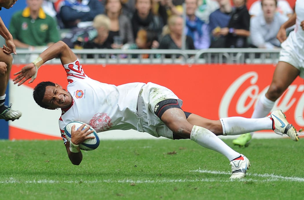 Tongan Atelea Okati of Tonga falls to the ground with the ball under pressure from Li Jialin of China during their match at the Hong Kong Sevens rugby tournament in Hong Kong on 27 March, 2010. Okati died following a car crash in December 2016.